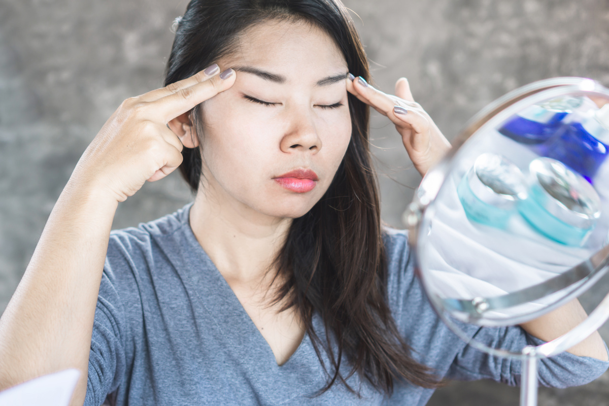Asian woman practicing yoga facial exercises for lifting her eyes